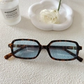 Gros plan de lunettes de soleil rectangulaires en écaille avec des verres bleu clair - Écaille Bleu