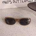 Detail van vintage amberkleurige ovale zonnebril met metalen puntversieringen op frame - Grijs