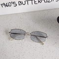 Detail shot of vintage cat-eye sunglasses with gray-blue lenses on a textured surface - Silver Frame Light Gray Lens