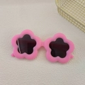 Detail of pink flower-shaped frame and dark lenses on children's fashion sunglasses - Pink