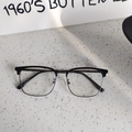 Detail view of half-rim browline glasses showing the silver metal frame and nose pads - Solid Black Clear Lens