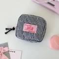 Detail of heart-shaped quilted black and white checkered pouch with pink zipper pull - Black