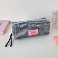 Close-up of quilted heart stitching on a black and white checkered pencil case with logo - Black