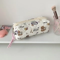 Close-up of a white quilted pencil case with cute dog prints and a pink cord zipper pull - Beige Dog
