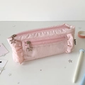 Détail de la trousse rose plissée avec bords à volants et fermetures éclair en étoile - Rose