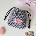 Close-up of heart-quilted plaid drawstring storage bag with pink label and ribbon decoration - Black