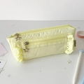 Gros plan d'une trousse jaune clair avec bords à volants et fermeture éclair étoile - Jaune