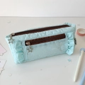 Detail of light blue pleated pencil case with double star zippers and woven label - Blue