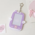 Macro detail of purple glitter acrylic photocard holder with white wings and star keychain - Purple