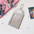 Detail of silver card holder with pink bear print and metal chain on white surface - Apple