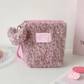 Detail of pink leopard plush makeup bag with heart charm and soft furry texture - Light Pink
