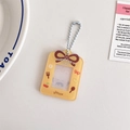 Detail of yellow acrylic card holder with cherry bow patterns and silver bead chain - Yellow