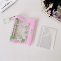 Macro detail of pink checkered mini binder with clover charm and five-ring metal binder - Pink