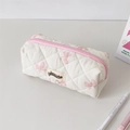 Détail d'une trousse matelassée blanche avec nœuds roses et étiquette de marque - Nœud Rose