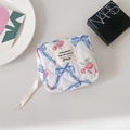 Close-up of quilted fabric sanitary pouch with blue bows and pink floral pattern - Blue