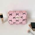 Detailed view of pink quilted makeup bag with black bow patterns and zipper closure - Black Bow