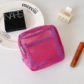 Dettaglio della borsa trucco in rete fucsia con zip blu, trama a griglia e etichetta - Rosa