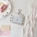 Silver ballet-style card holder with heart buckle and metallic eyelets on white surface - Horizontal