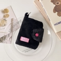 Detalle del tarjetero de felpa negra con botón rosa y etiqueta de marca - Negro