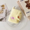 Detalle de monedero de felpa amarilla con botón a presión rosa y mosquetón de metal plata - Amarillo