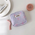 Detail view of purple checkered makeup pouch with cute bow pattern and brand label - Purple Plaid