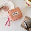 Detailed shot of quilted orange checkered small makeup pouch with branded woven label - Orange