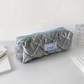 Détail de la trousse matelassée argentée avec fermeture éclair bleue et étiquette - Gris Argent