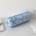Vue détaillée de la trousse matelassée bleu clair avec un écusson de personnage décoratif - Bleu clair