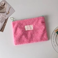 Primer plano de bolsa de cosméticos de felpa rosa con cremallera verde y textura suave - Rosa Rojo