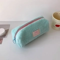 Dettaglio dell'astuccio in peluche verde menta con logo in pelle rosa e cerniera blu - Verde