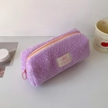 Dettaglio dell'astuccio in peluche viola con cerniera e toppa con logo Lucky Gate - Viola
