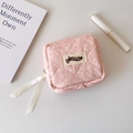 Detailansicht der rosa gesteppten Mini-Tasche mit Schleifen-Reißverschlüssen und Logo-Etikett - Rosa