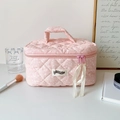 Pink quilted cosmetic bag with white polka dots, top handle and ribbon zipper detail - Pink