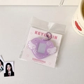 Close-up of purple heart-shaped photo holder with white angel wings and glitter finish - Purple