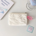 Close-up of white quilted organizer pouch with butterfly texture and pink lanyard - Butterfly Quilting / White