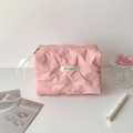 Close-up of pink quilted cosmetic bag with butterfly pattern and silk ribbon zipper - Pink
