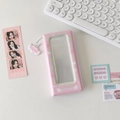 Macro detail of pink photo album with angel wing charm and heart-shaped patterns - Pink
