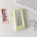 Detail of light yellow photo album with clear window and angel wing pendant on a desk - Yellow
