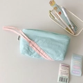 Detalle de estuche azul claro con asa rosa y artículos de papelería en escritorio limpio - Azul lago