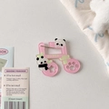 Primer plano de dije de nota musical rosa en acrílico con pandas y pin de seguridad metálico - Nota musical