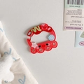 Macro view of red translucent acrylic carabiner with cute octopus and star charms - Octopus