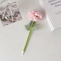 Detail of pink carnation flower ballpoint pen with green leaves on minimalist white desk - Pink