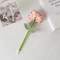 Detail of carnation flower ballpoint pen with pink-edged petals on an aesthetic desk - Yellow Red