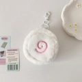 Close-up of white plush fish cake pouch with pink spiral embroidery and white clip - White