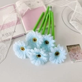 Detail of five light blue sunflower pens arranged on a pink notebook with lace - Blue