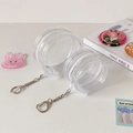 Macro shot of two round clear PVC badge storage bags with smooth zippers and keychains - Large With Pendant (Fits 75mm Badges)