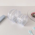 Macro shot of dual-sized clear PVC cylindrical storage bags with silver metal zippers - Large Without Pendant (Fits 75mm Badges)