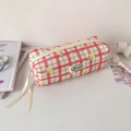 Gros plan d'une trousse à carreaux rouges avec motifs cerises et rubans décoratifs - Rose