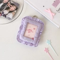 Macro shot of light purple fabric photocard holder with ruffled edges and metal hook - Purple