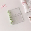 Detail eines transparenten PVC-Ordners mit hellgrünen 6-Loch-Ringen und elastischem Band - Grün (Nur Schale)
